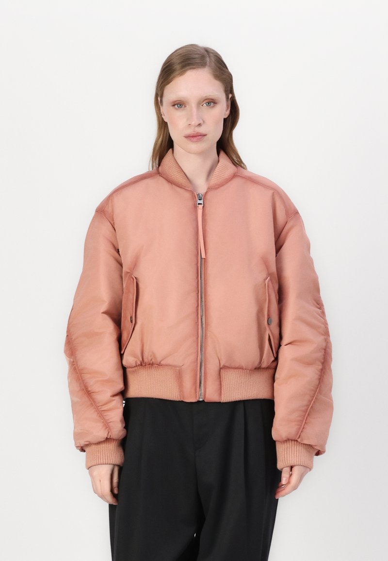 Light pink bomber jacket with a zip front, ribbed cuffs and hem, and side pockets. Smooth texture with padded, voluminous design.