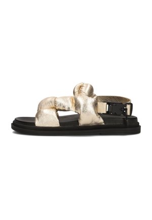 Metallic gouden puffy sandaal met gekruiste banden en een zwarte rubberen zool. Voorzien van een verstelbare gesp voor een veilige pasvorm.