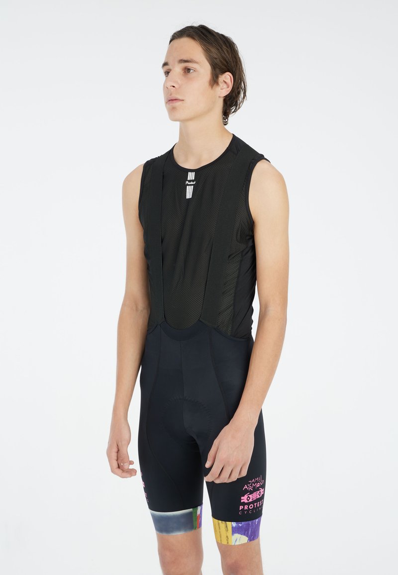 Bretelles de cyclisme noires avec un haut sans manches ajusté, en matériau en maille et des accents colorés sur les shorts. Texte sur le devant.