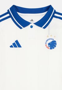 Biely športový dres s modrým golierom, logo Adidas na ľavej strane a emblém FC København s levom a tromi zlatými hviezdami na pravej hrudi.