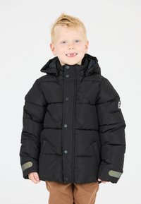 Giacca a vento nera con cappuccio, con un design trapuntato, grandi bottoni e dettagli grigi ai polsini. Indossata da un bambino.