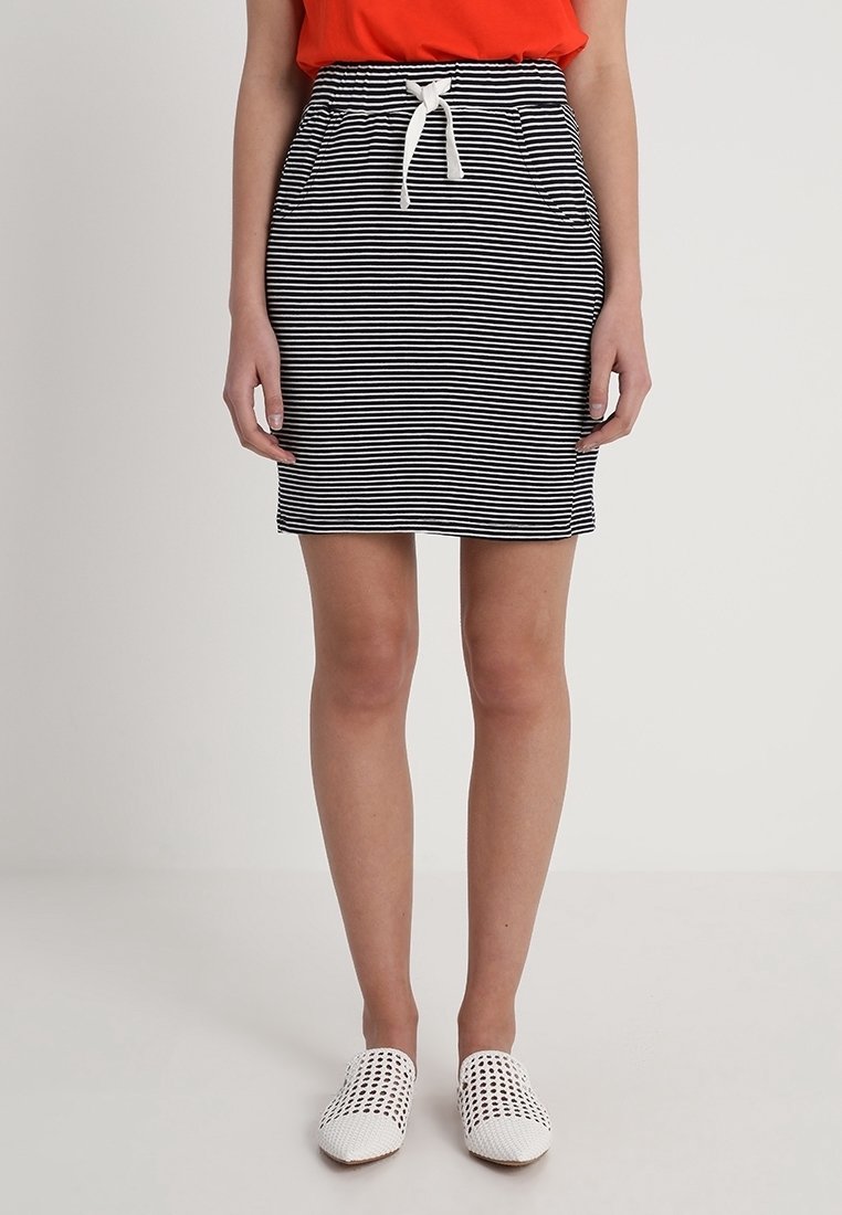 Randig svart och vit kjol med resårmidja och vit dragsko, med framfickor och en åtsittande design.