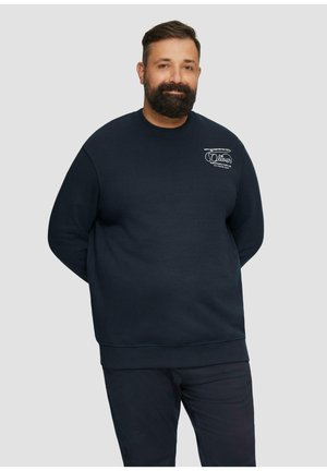 Navyblauwe sweatshirt met ribbelboorden en -zoom. Voorzien van een klein wit logo op de borst. Zachte textuur, losse pasvorm. Gecombineerd met donkere broeken.