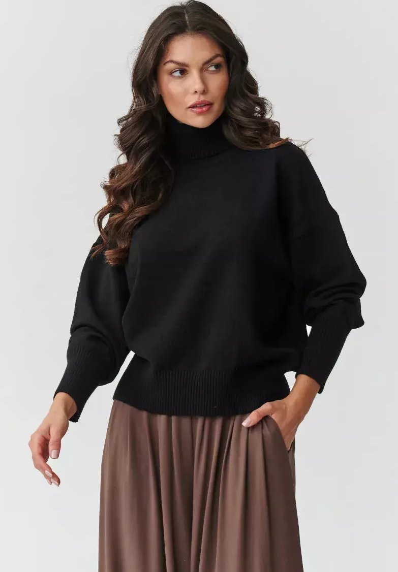 Czarny sweter z golfem, z luźnymi rękawami, ściągaczami przy mankietach i na dole. Nosi się go na brązowej, plisowanej spódnicy. Miękki dzianinowy materiał, luźny fason.