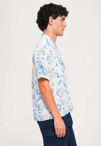 Camicia a maniche corte, di colore chiaro, con una stampa a tema marino blu che presenta meduse e coralli. Vestibilità rilassata con colletto.