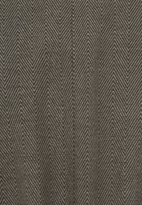Tessuto texture in marrone e argento con un motivo a spina di pesce, caratterizzato da linee a zigzag e una finitura superficiale liscia.