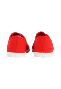 Scarpe slip-on rosse in tela con suole in gomma bianca, punta arrotondata e due bande elastiche per il comfort. Texture liscia con minimal branding.