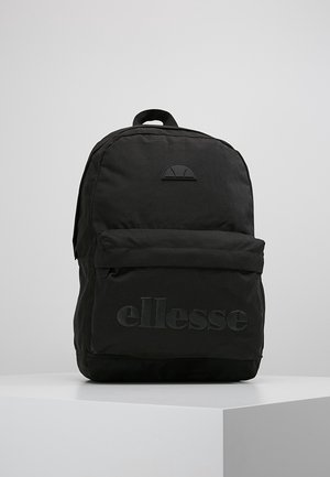 Czarny plecak ellesse z przednią kieszenią na zamek błyskawiczny i górnym uchwytem, prezentowany na białym postumencie na szarym tle.