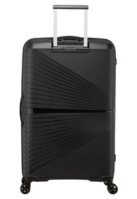 Valigia nera in policarbonato con una texture a coste diagonali. Dotata di manico retrattile e quattro ruote girevoli per una facile mobilità.