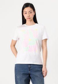 Balta medvilninė T-shirt marškinėliai su pastelinių gėlių raštu, papuoštu rožinėmis, žaliomis ir geltonomis detalėmis. Trumpomis rankovėmis ir apykakle.