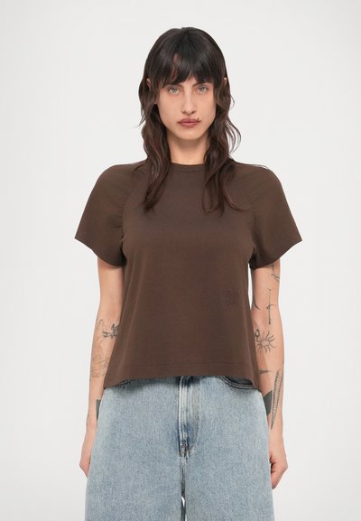 T-shirt marron à manches courtes avec col rond, en tissu doux, présentant un logo subtil sur le devant et une coupe décontractée.