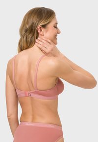 Sanftes rosa Dessous-Set mit einem glatten, leicht gepolsterten BH, verstellbaren Trägern und einem Haken-und-Öse-Verschluss auf der Rückseite.