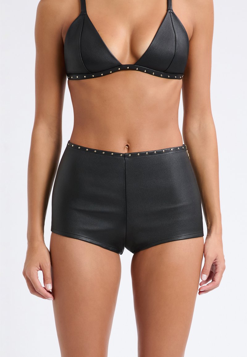 Set bikini nero composto da un reggiseno triangolare e pantaloni corti a vita alta, realizzato in materiale morbido con dettagli in metallo dorato lungo i bordi.