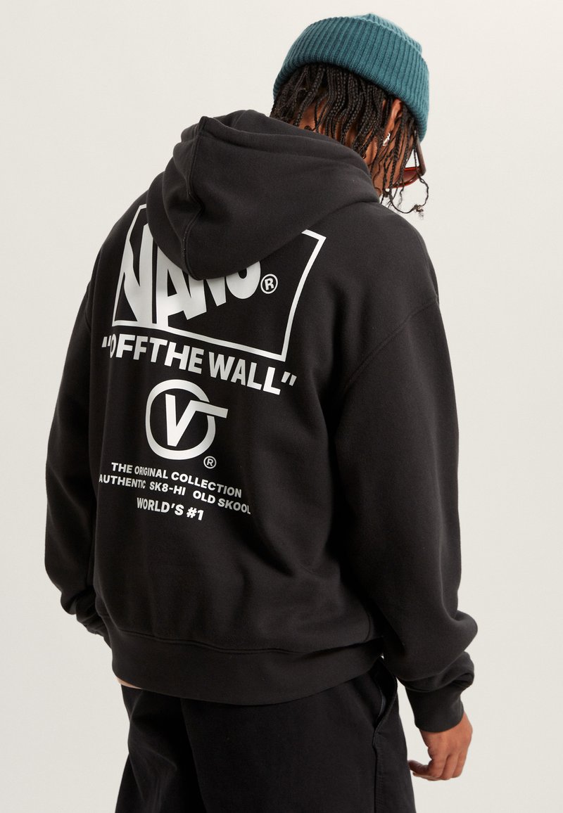 Sudadera negra con el destacado logo blanco de Vans y texto en la parte posterior. La tela parece suave con un acabado texturizado.