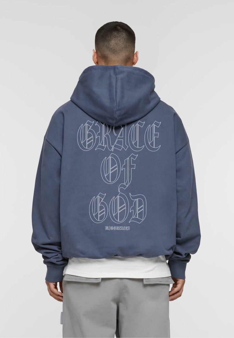 Donkerblauwe oversized hoodie van een katoenmix, met de tekst "GRACE OF GOD" in grote witte letters op de achterkant, en een hoodie met trekkoord.