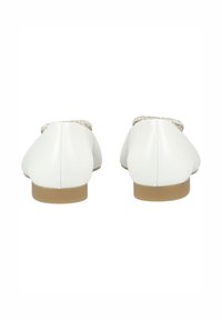 Zapatos planos de cuero blanco con punta redondeada y pequeños tacones de goma marrón. La parte trasera presenta un detalle tejido a lo largo del borde superior.