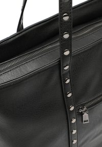 Black leather tote bag with a structured design, featuring a zip closure and decorative metallic studs along the strap. Textured surface.