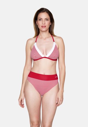 Frau steht mit dem Gesicht nach vorne und trägt einen rot-weiß gestreiften Neckholder-Bikini mit hoch tailliertem Slip vor einem schlichten weißen Hintergrund.