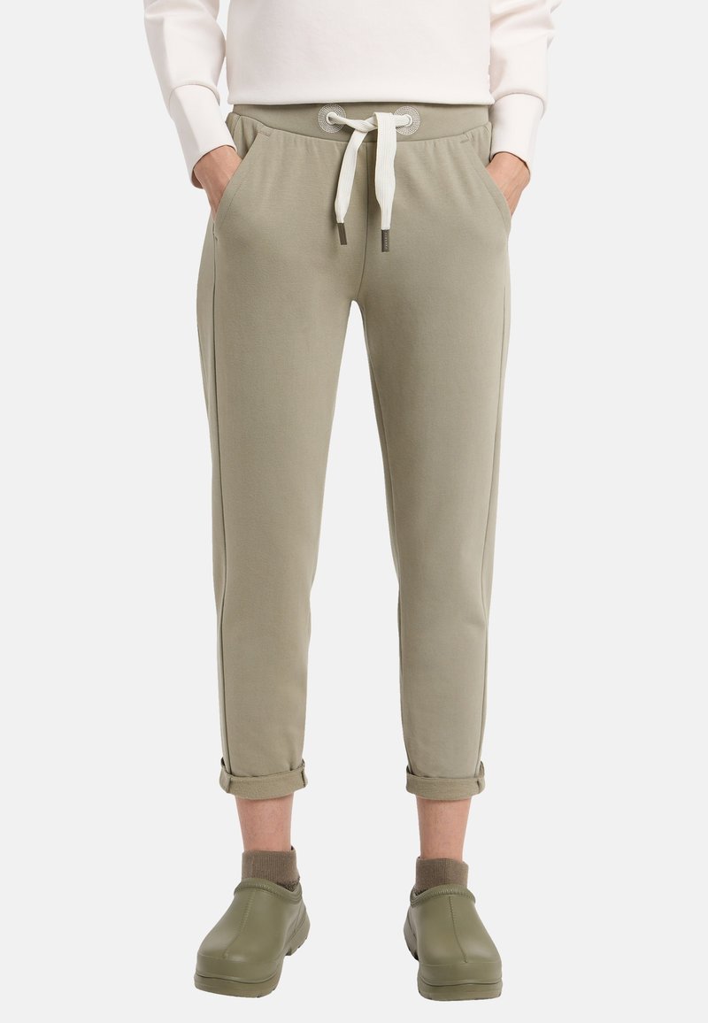 Helle olivgrüne Jogginghosen mit schmaler Passform, elastischem Bund, weißem Kordelzug, seitlichen Taschen und hochgerollten Säumen über dem Knöchel.