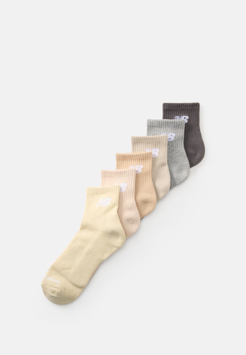 Septynios poros trumpų kojinių, rodančių briaunotą tekstūrą, geltonos, smėlio, pilkos ir tamsiai rudos spalvų, su baltu logotipu šone.