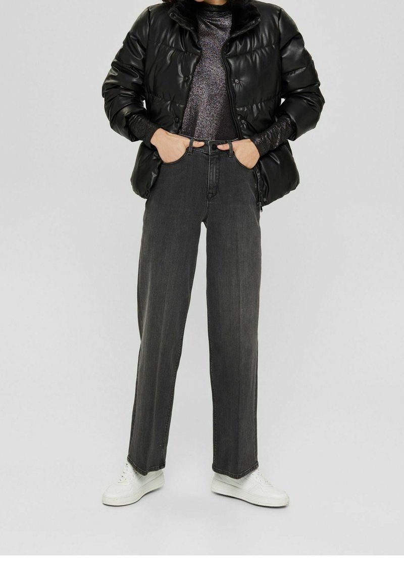 Svart puffjacka, ribbad svart tröja, grå vida jeans och vita sneakers. Har glansig finish och avslappnad passform.