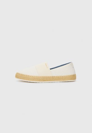 White canvas espadrille with a woven jute sole and elastic side panels; features a subtle logo on the side and a textured beige ribbon.