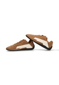 Zapatillas de ante marrón con una franja de cuero blanca, punta redondeada, suela de goma negra y cinco ojales para los cordones.