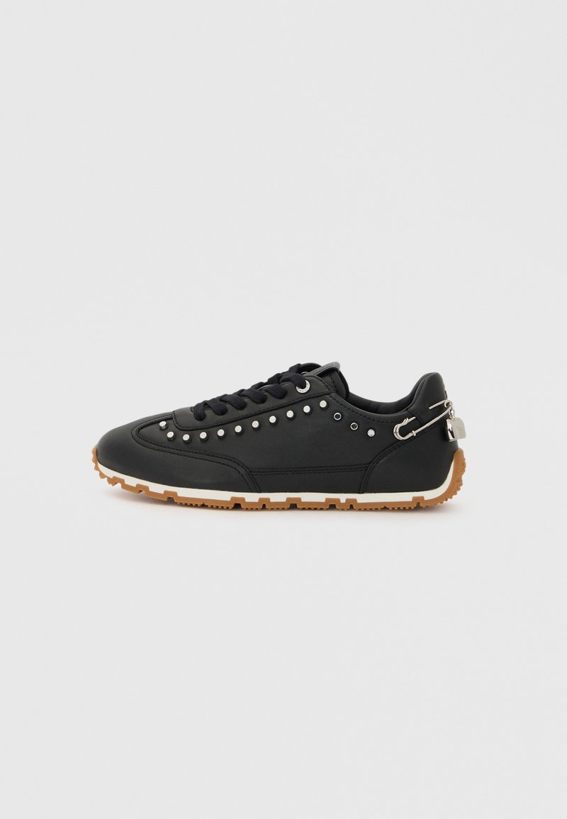 Zwarte sneaker van synthetisch materiaal, met een geperforeerd ontwerp, ronde neus, vetersluiting aan de voorkant en een gumrubberen zool met een metalen accent in zilver.