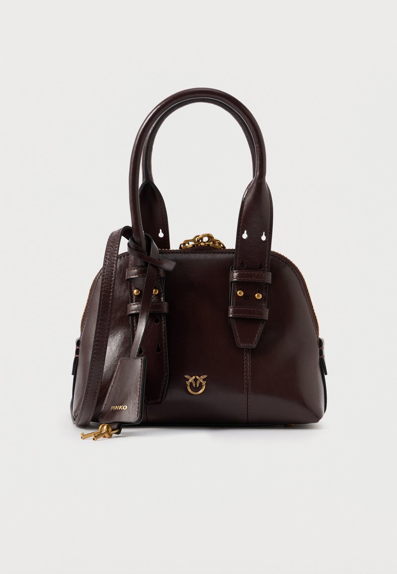 Mörkbrun läderhandväska med dubbla handtag, guldtonad hårdvara, en liten fågel-logotyp och ett avtagbart axelband med nyckeldetalj.