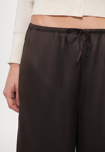 Brown satin wide-leg pants with an elastic waistband and a drawstring detail, showcasing a smooth and glossy surface texture.