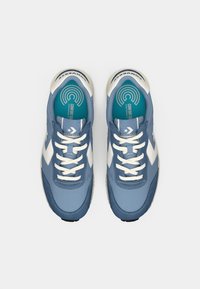 Blue athletic sneakers with smooth leather texture, white accents, and a teal insole. Features flat white laces and a black rubber sole.