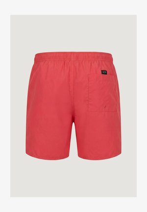 Bañador corto rojo para hombre con cintura elástica y un bolsillo trasero único que presenta un pequeño parche de logo negro en el lado derecho.