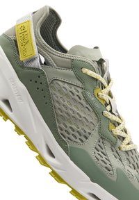 Sneaker verde e grigia con parte superiore in rete, dettagli testurizzati, patch del logo giallo e suola bianca imbottita con grip giallo.