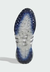 Suola di scarpa da corsa in gomma traslucida, con sfumatura dal blu al trasparente, superficie testurizzata e motivi di trazione neri. Tre strisce bianche.