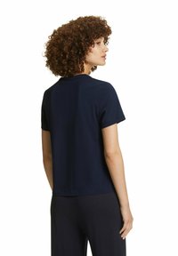 T-shirt blu navy a maniche corte con scollo rotondo, texture liscia e vestibilità rilassata. La maglietta termina poco sopra la vita.