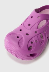 Sabot léger en mousse violet avec trous de ventilation et semelle texturée, conçu pour un usage décontracté et un nettoyage facile.