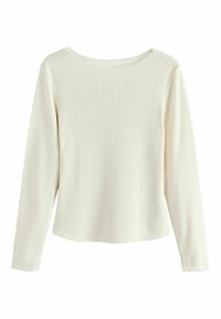 Long-sleeve top in cream, made of ribbed fabric with a textured pattern. Features a scalloped neckline and fitted design.