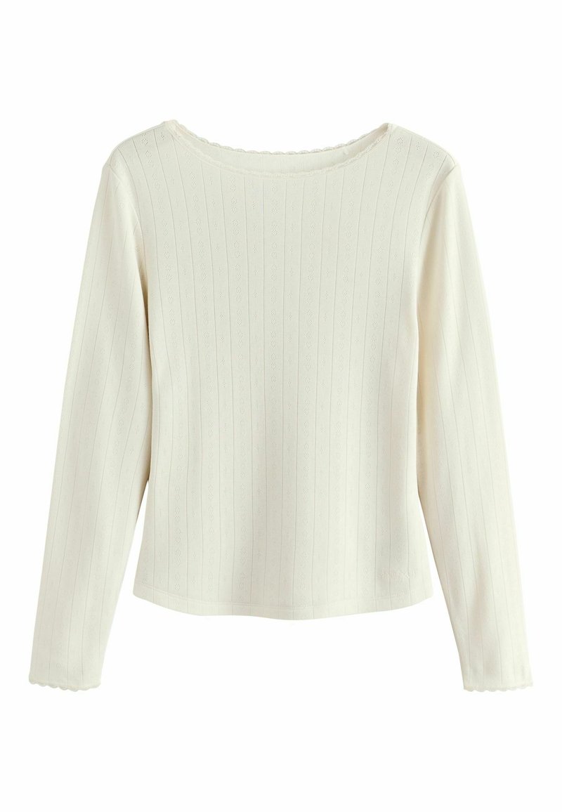 Long-sleeve top in cream, made of ribbed fabric with a textured pattern. Features a scalloped neckline and fitted design.