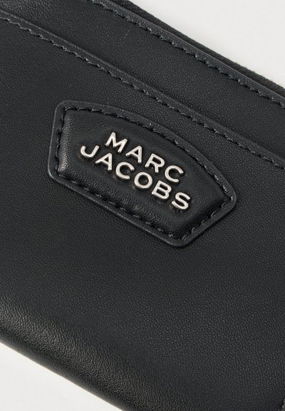 Μαύρο δερμάτινο πορτοφόλι με υφή, λεπτομερή ραφή και ραμμένο λογότυπο με ασημένια γράμματα.