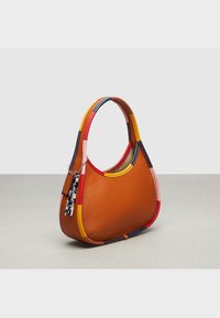 Pieni kuun muotoinen oranssi nahkainen käsilaukku, jossa on monivärinen reuna ja kahva. Laukkuun kuuluu leopardi-kuosisella avaimenperällä varustettu lisäosa.