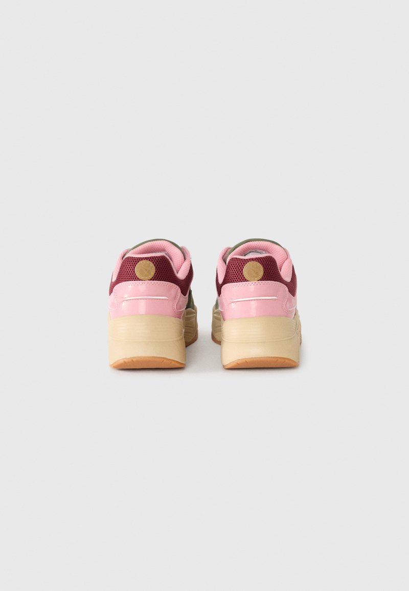 Un paio di sneakers chunky con dettagli rosa, bordeaux e beige, viste da dietro su uno sfondo chiaro e semplice.