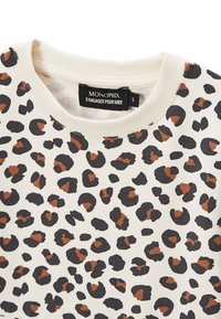 Sweatshirt à imprimé léopard en beige, avec des taches noires et brunes. Encolure ronde, tissu doux et détails de design classique.