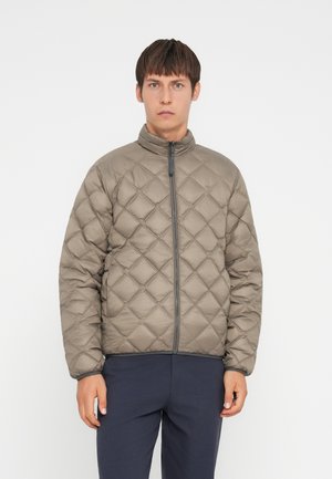 Veste matelassée et légère en gris-brun doux, avec un col montant et une fermeture éclair intégrale, ornée d'un motif en diamant et de poignets élastiqués.