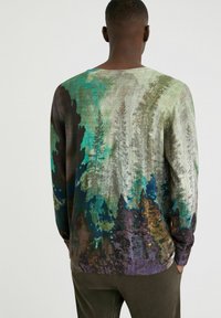 Trui met lange mouwen, voorzien van een meerkleurig bospatroon in verschillende tinten groen, bruin en blauw, gemaakt van een zachte, textuurrijke stof.