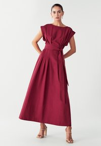 Bordo maxime mekko, jossa on lyhyet hihat, taitettu hame ja solmittava vyö. Sujuva pinta minimalistisella suunnittelulla eikä näkyviä kuvioita.