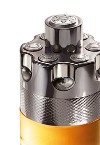 Bottiglia di profumo con un cappuccio metallico e un design circolare sulla parte superiore. Presenta dettagli testurizzati in argento e un corpo in vetro di colore ambra.