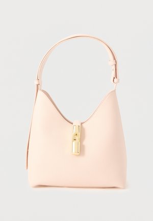 Sac à main en cuir rose clair avec un dessus arrondi et une bandoulière unique, présentant une fermeture centrale dorée sur un fond uni.