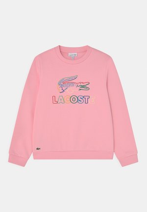Rosa Sweatshirt aus Baumwolle mit Rundhalsausschnitt. Mit einem mehrfarbigen Krokodil-Logo und dem Schriftzug "LACOSTE" darunter. Gerippte Bündchen.