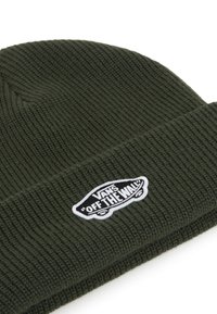 Olive green knit beanie made of ribbed fabric, featuring a black and white "VANS OFF THE WALL" logo patch on the front.