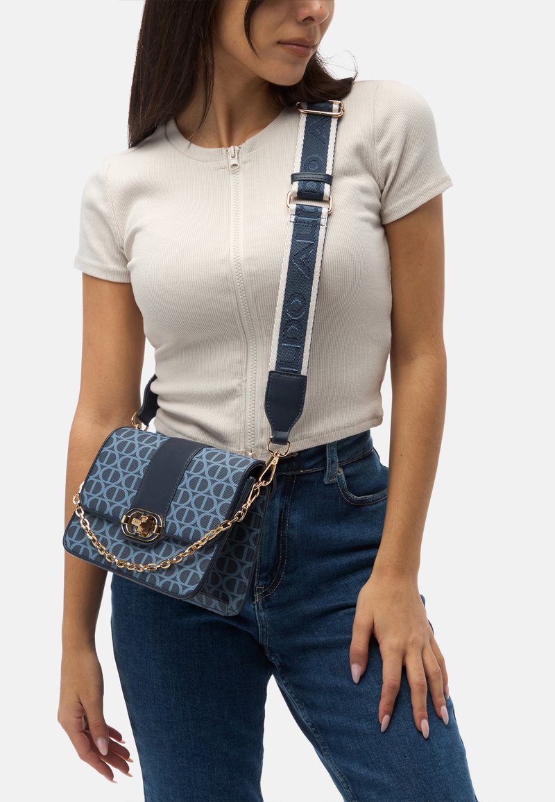 Blue patterned crossbody bag with a gold chain accent, featuring a smooth leather strap and a rectangular shape.